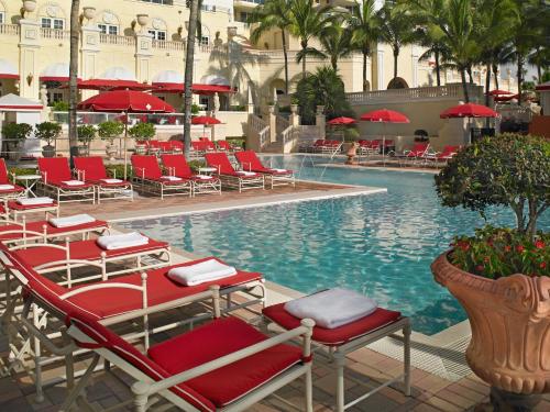a pool with chairs and umbrellas in a resort at Acqualina Resort and Residences in Miami Beach