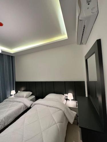 a bedroom with two beds and a mirror on the wall at modern 2bedroom for rent abdoun2 in Amman