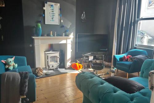 un soggiorno con sedie blu e camino di Charming 3BD House wPrivate Garden - Bristol a Bristol