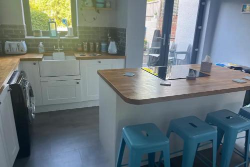 una cucina con bancone e 2 sgabelli blu di Charming 3BD House wPrivate Garden - Bristol a Bristol