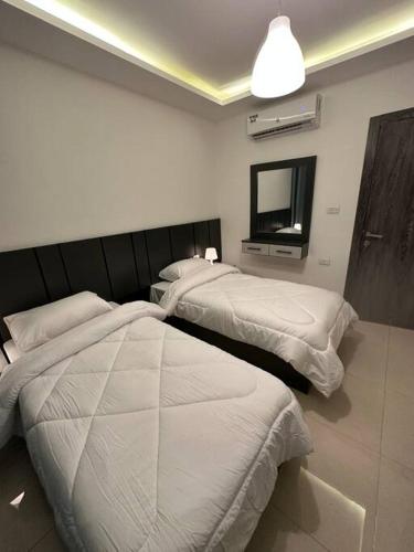 a hotel room with two beds and a mirror at modern 2bedroom for rent abdoun2 in Amman
