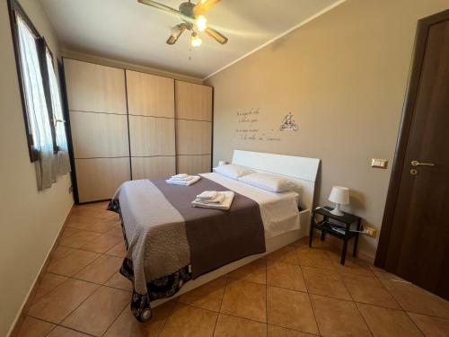 a bedroom with a bed and a ceiling fan at Attico Etnamare in Gravina di Catania