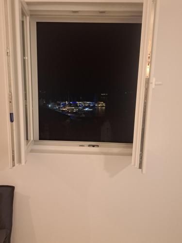 een raam met uitzicht op de stad 's nachts bij Sea view in Hvar