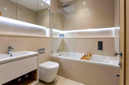 a bathroom with a tub and a toilet and a sink at Exclusive 3 Bedroom Penthouse - 2 Bath & Mezzanine in Harrogate
