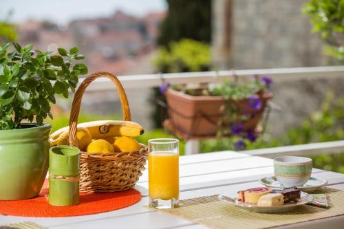 a table with a basket of fruit and a glass of orange juice at Blue Lagune in Dubrovnik