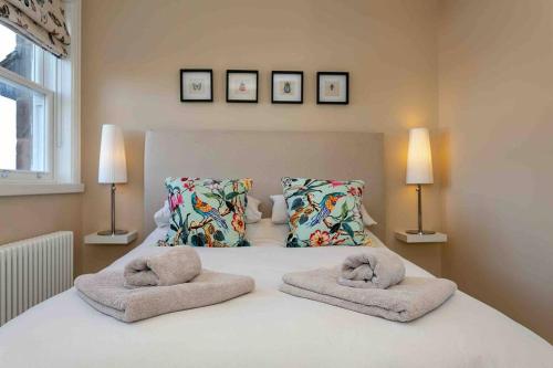 ein Schlafzimmer mit einem weißen Bett und Handtüchern darauf in der Unterkunft Exclusive 3 Bedroom Penthouse - 2 Bath & Mezzanine in Harrogate
