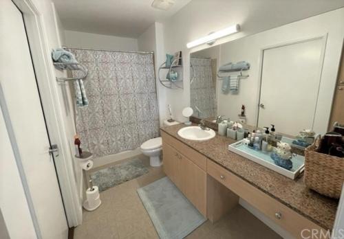 a bathroom with a sink and a toilet and a mirror at Ocean Views Penthouse 2b 2b Majestic Apartment 5 min to Convention Center in Long Beach