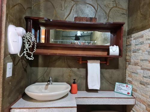 a bathroom with a sink and a mirror at Cabina Arenal Z13 in Fortuna