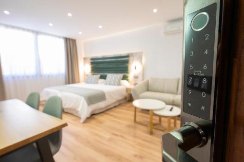 a hotel room with a bed and a couch at Laguna Home & Suites in La Laguna