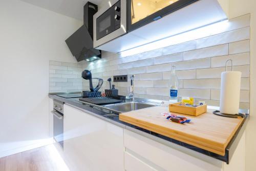 a kitchen with a sink and a wooden cutting board at Laguna Home & Suites in La Laguna