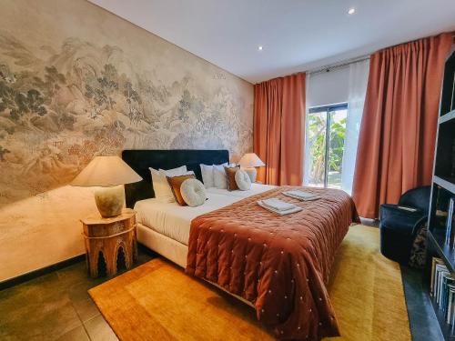 sypialnia z łóżkiem i obrazem na ścianie w obiekcie Villa Monte Canelas w mieście Portimão