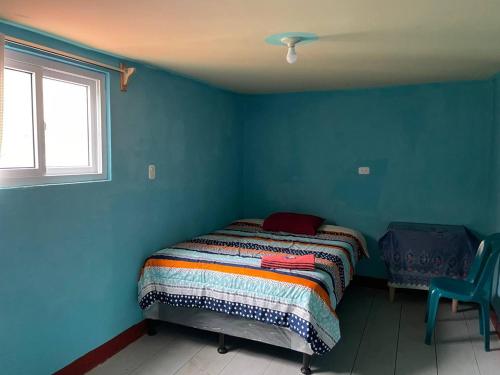 ein Schlafzimmer mit einem Bett in einer blauen Wand in der Unterkunft Casa Julia Xela in Quetzaltenango