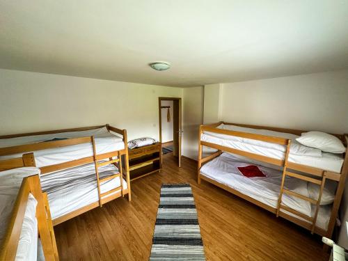 PazarićにあるMusafir's Houseの二段ベッド2台とラグが備わる客室です。