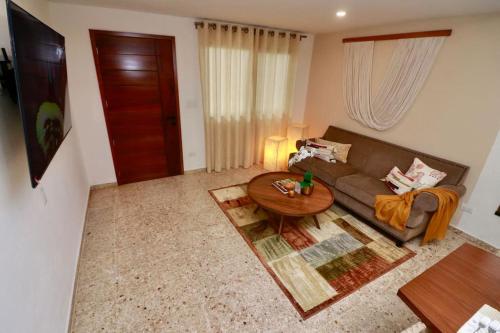 ein Wohnzimmer mit Sofa und Tisch in der Unterkunft Casa Belcher in Cozumel