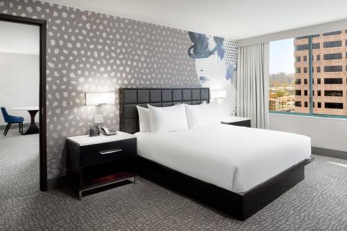 a bedroom with a large white bed and a window at Hilton Woodland Hills/ Los Angeles in Woodland Hills