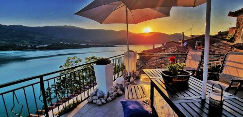 balkon z parasolem i widokiem na rzekę w obiekcie La terrazza sul lago Turano w mieście Vermiglio