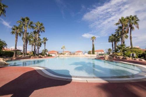 uma grande piscina com palmeiras num resort em Casa Alanis em Gran Alacant