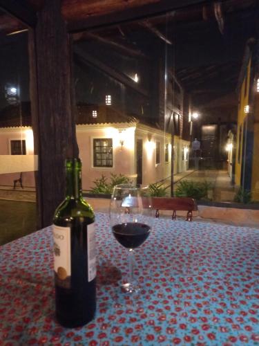 a bottle of wine and a glass on a table at Villa Amore Floripa in Florianópolis