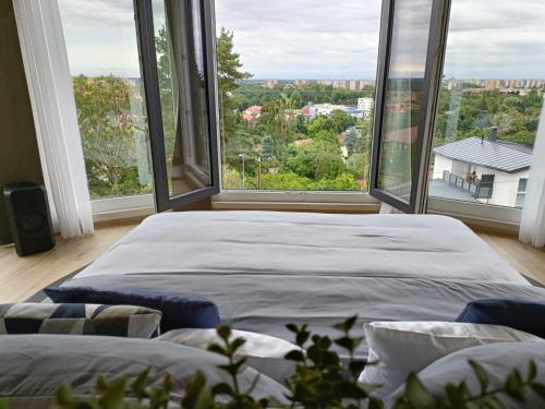 1 cama grande en una habitación con ventanas grandes en WEST Panorama Penthouse - apartment with a fantastic view of the city, en Szombathely