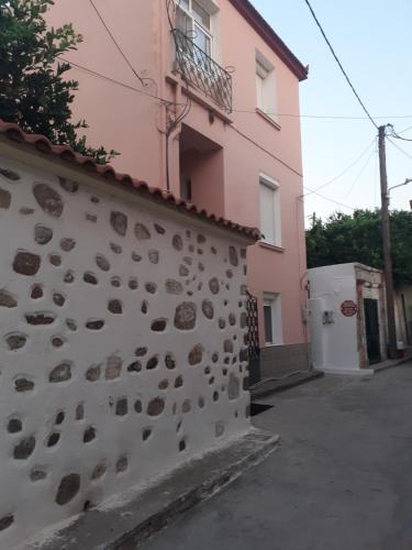 a wall with rocks on it next to a building at THALIA'S GARDEN in Mytilini