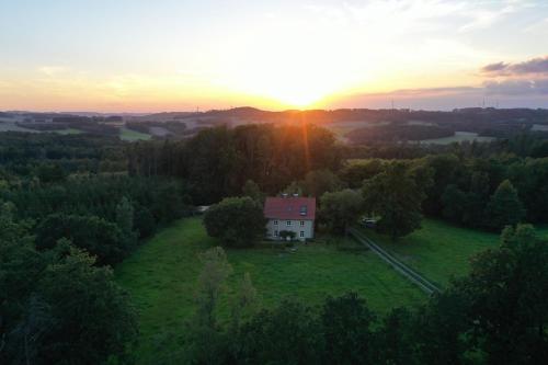 ein Haus auf einem Feld mit Sonnenuntergang im Hintergrund in der Unterkunft Erholen und Wohlfühlen Auf dem Knick in Detmold