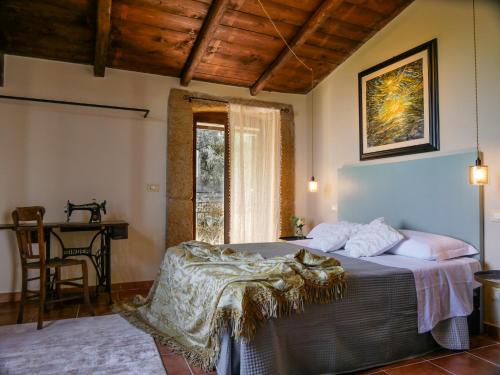 um quarto com uma cama, uma mesa e uma janela em Dimora d'Arte Mariano Pietrini em Barcellona Pozzo di Gotto