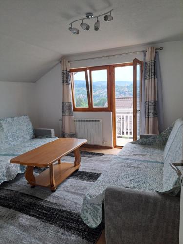 a room with two beds and a wooden table at Apartments Neyla in Sarajevo