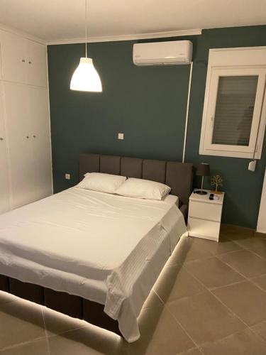 1 dormitorio con 1 cama grande y pared verde en Glyfada apartment near the Center, en Atenas