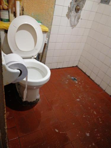 een vuile badkamer met een toilet in een stal bij Casa familiar in Soacha