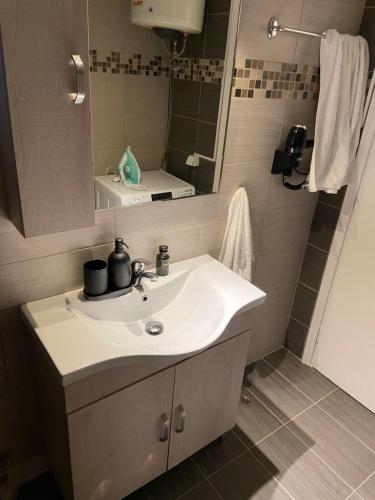 a bathroom with a sink and a mirror at Glyfada apartment near the Center in Athens