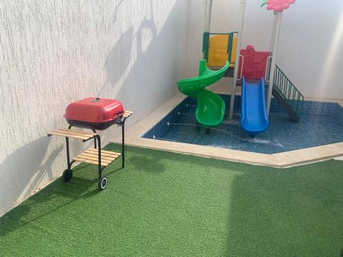 a room with a play room with a pool and a playground at شاليهات تركواز in Ash Shuwaybiţ