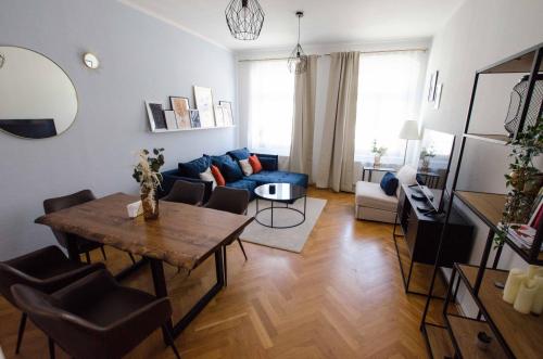 uma sala de estar com uma mesa e um sofá azul em Stilvoller Altbau in zentraler Lage em Dresden