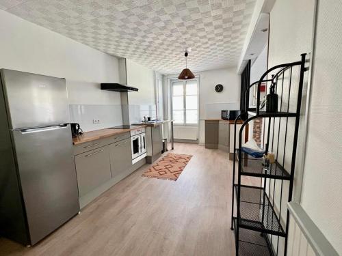uma cozinha com um frigorífico e uma escadaria. em LE PETIT VOLTAIRE - Proche Centre Ville - Spacieux em Châteauroux