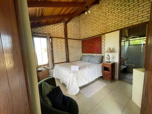 a bedroom with a bed and a chair in a room at Guest House Jardim Botânico Brasília in Brasilia