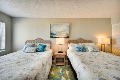 two beds sitting next to each other in a bedroom at Inviting Virginia Beach Condo with Community Pool in Virginia Beach