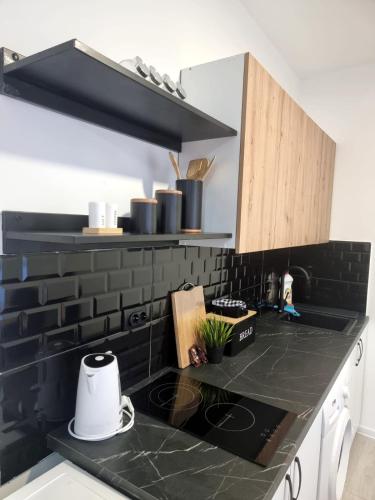 a kitchen with a black counter top and a stove at Industrial Home Vršac in Vršac