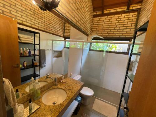 a bathroom with a sink and a toilet and a shower at Guest House Jardim Botânico Brasília in Brasilia
