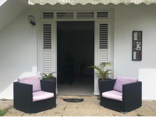 2 chaises assises sur la terrasse couverte d'une maison dans l'établissement Jireh-plénitude, à Fort-de-France