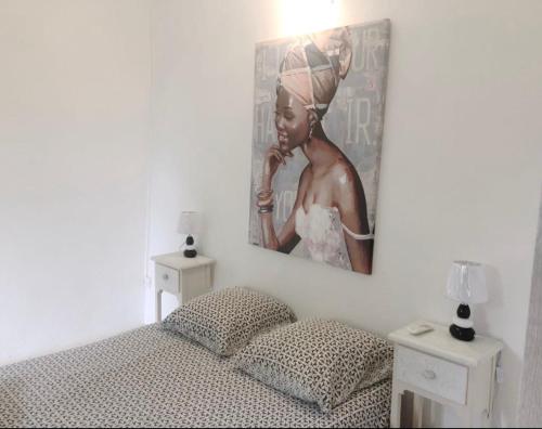 フォール・ド・フランスにあるJireh-plénitudeのベッドルーム1室(ベッド1台付)が備わります。壁には絵画が飾られています。