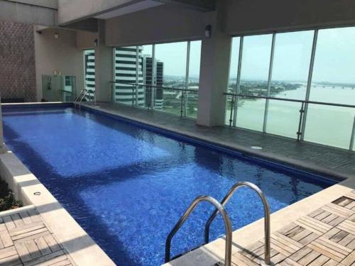 a large swimming pool in a building with a view at Suite 806 extraordinaria vista al rio con piscina. in Guayaquil