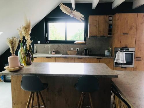 une cuisine avec un grand comptoir et deux tabourets dans l'établissement Grand T5 avec terrasse vue sur les montagnes, à Gap