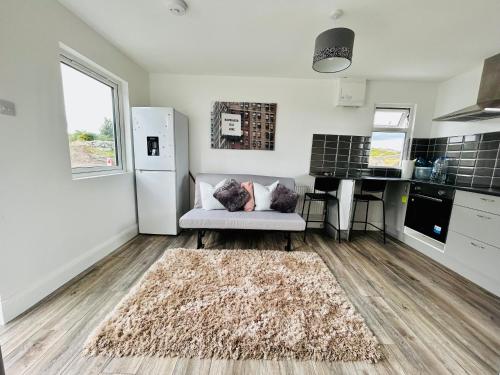 a living room with a white couch and a kitchen at Ocean View Apartment - Connemara in Galway