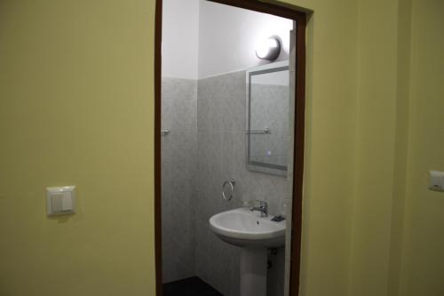 a bathroom with a sink and a mirror at Hotel Mondo in Gjirokastër