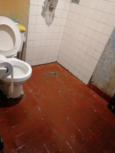 a bathroom with a toilet and a tiled floor at Casa familiar in Soacha