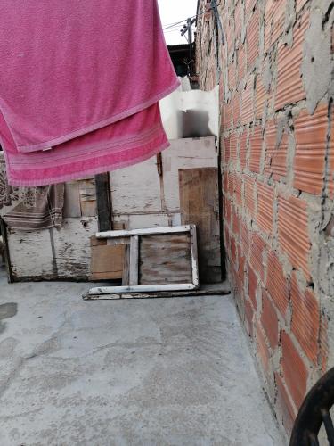 a brick wall with a pink curtain next to a building at Casa familiar in Soacha