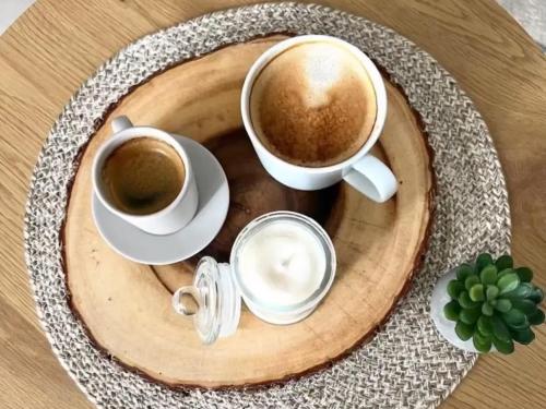two cups of coffee sitting on a wooden plate at Industrial Home Vršac in Vršac