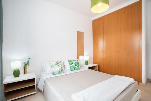 sypialnia z białym łóżkiem i drewnianą szafką w obiekcie Borboletas Loft w mieście Quinta do Anjo
