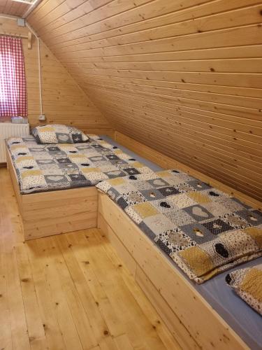 a bedroom with two beds in a wooden room at BRINA Pokljuka in Zgornje Gorje