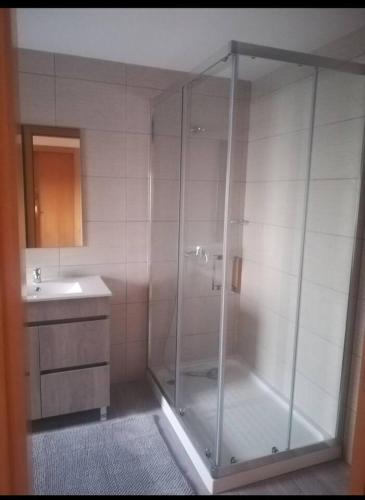 a bathroom with a glass shower and a sink at Casa do Ribeiro in Chão de Couce