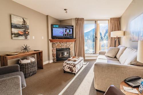a living room with a couch and a fireplace at Cascade in Whistler